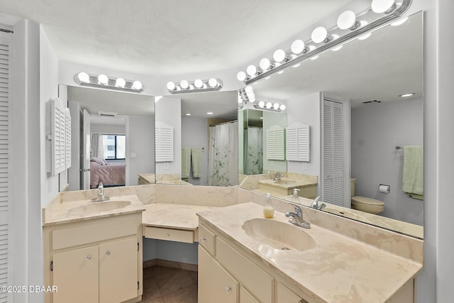 bathroom with visible vents, toilet, tile patterned floors, vanity, and a closet