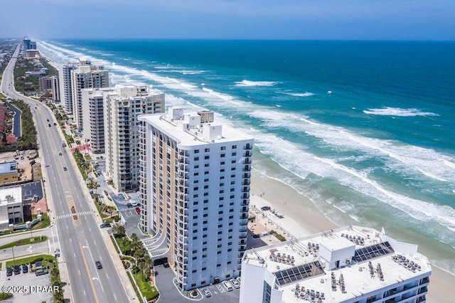 drone / aerial view featuring a view of the beach, a water view, and a city view