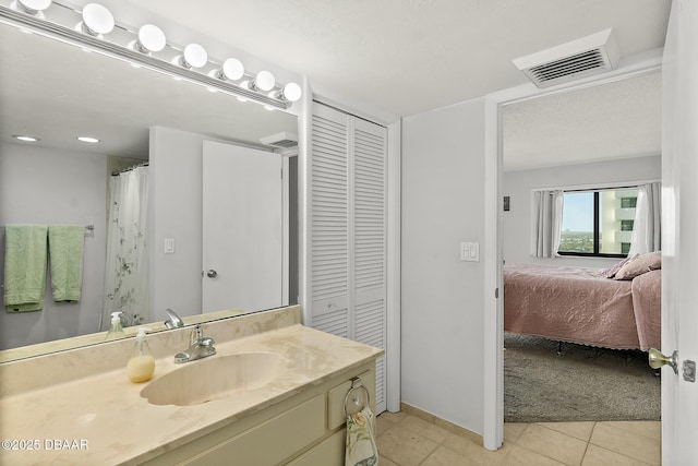 full bath featuring a closet, visible vents, vanity, and tile patterned floors