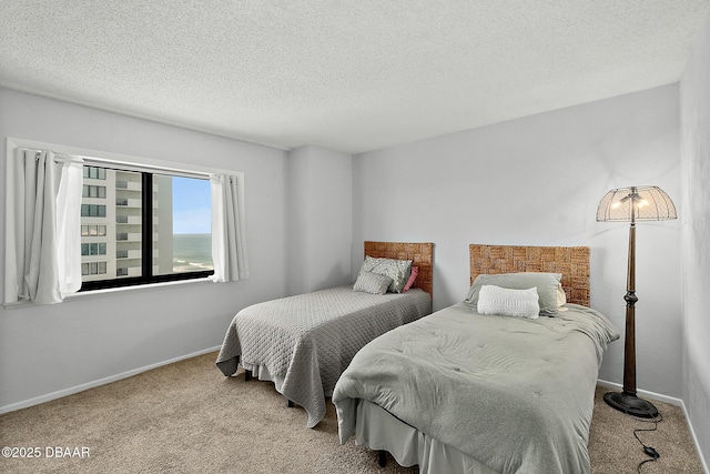 bedroom with a textured ceiling, carpet flooring, and baseboards