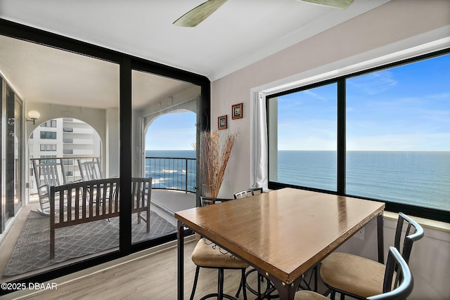 dining room with a water view and light wood-style flooring