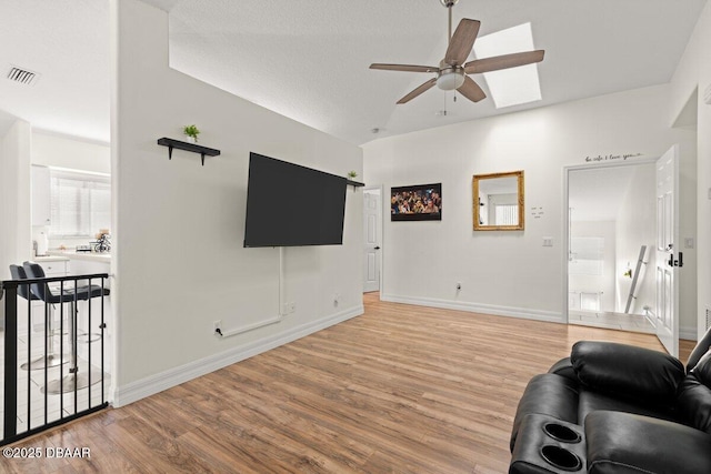 living room with wood-type flooring, ceiling fan, and vaulted ceiling