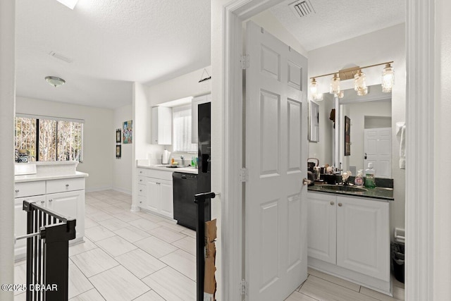 bathroom featuring vanity, a wealth of natural light, and a textured ceiling