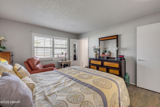 bedroom with wood finished floors and a textured ceiling