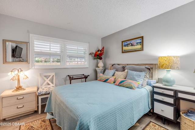 bedroom with wood finished floors and a textured ceiling