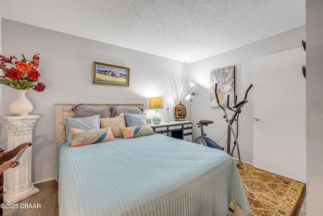 bedroom with wood finished floors and a textured ceiling