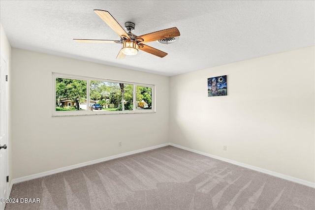 carpeted spare room featuring ceiling fan and a textured ceiling