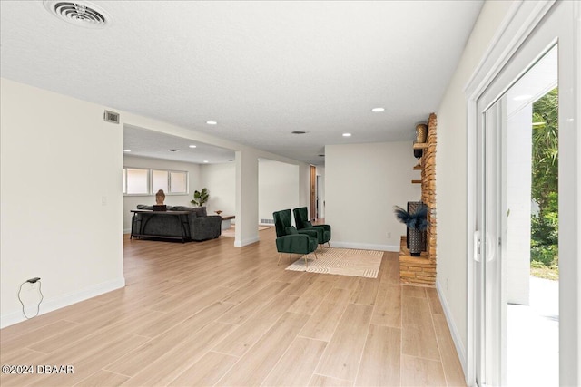 interior space with a textured ceiling and light hardwood / wood-style floors