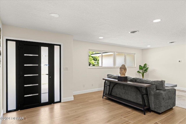 living room featuring light hardwood / wood-style flooring and a textured ceiling