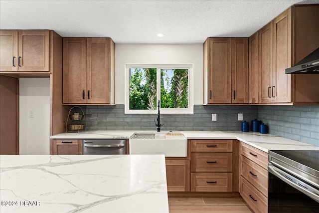 kitchen featuring appliances with stainless steel finishes, sink, tasteful backsplash, and light stone countertops