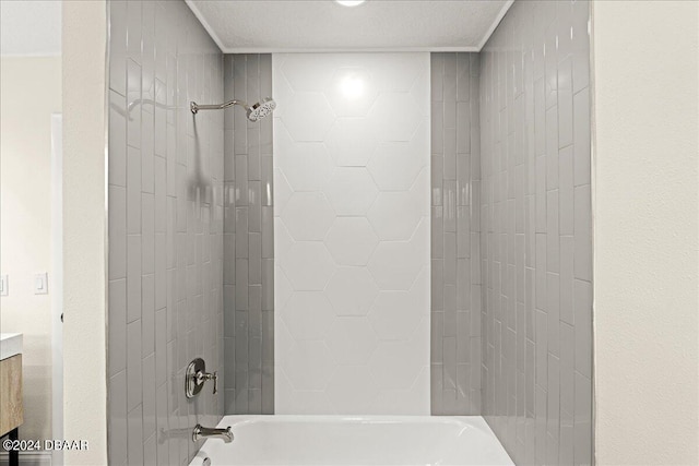 bathroom featuring vanity, tiled shower / bath, and a textured ceiling