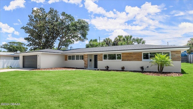 ranch-style home featuring a garage and a front lawn