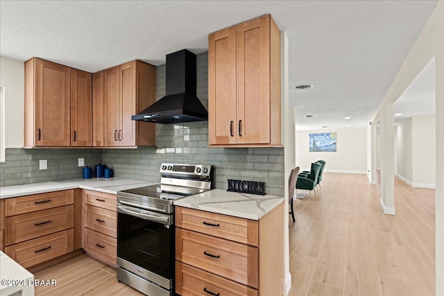 kitchen featuring stainless steel range with electric cooktop, wall chimney range hood, a textured ceiling, decorative backsplash, and light hardwood / wood-style flooring