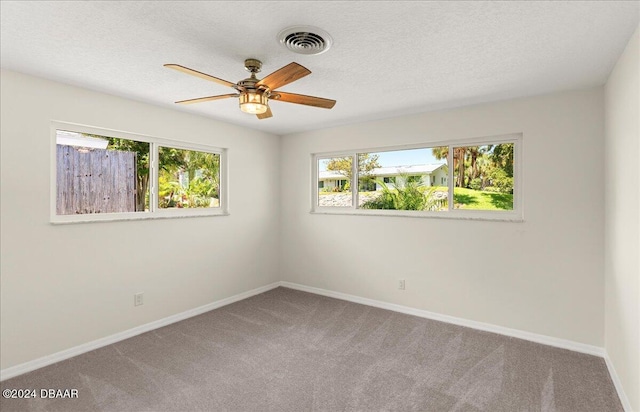 spare room with ceiling fan, a textured ceiling, and carpet