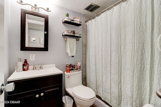 bathroom featuring vanity, a textured ceiling, and toilet