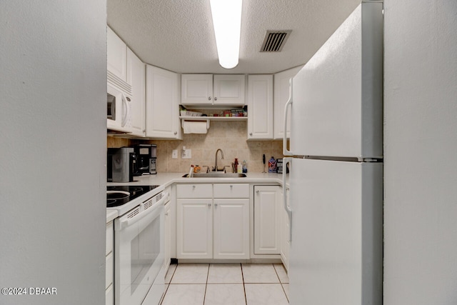 kitchen featuring white cabinetry, sink, tasteful backsplash, light tile patterned floors, and white appliances