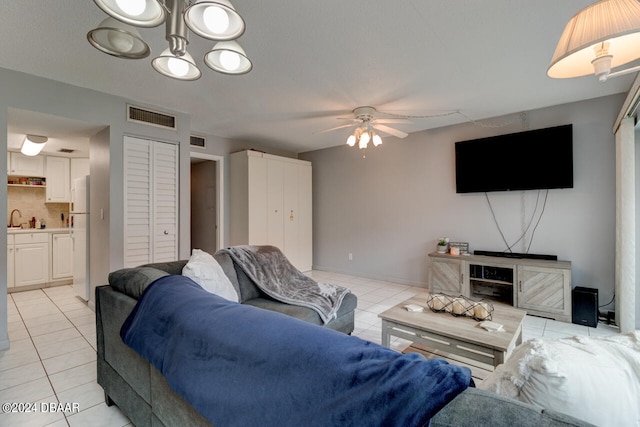 living room with sink, ceiling fan, and light tile patterned floors