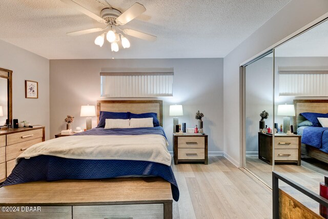 bedroom featuring ceiling fan, a textured ceiling, a closet, and light wood-type flooring