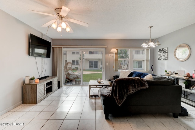 tiled living room with ceiling fan with notable chandelier and a textured ceiling