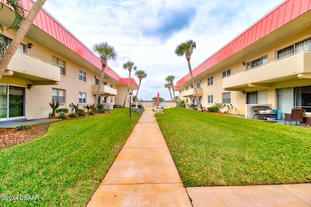 view of home's community with a patio area and a lawn