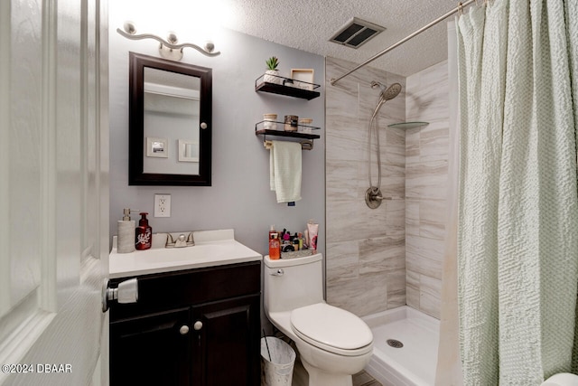 bathroom with walk in shower, vanity, toilet, and a textured ceiling