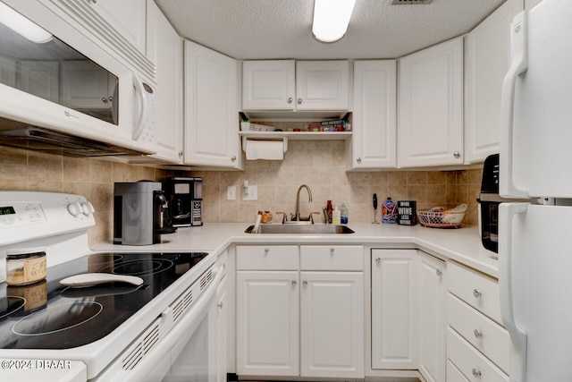 kitchen with white cabinetry, a textured ceiling, sink, and white appliances