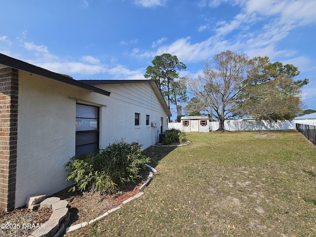 view of yard featuring a fenced backyard, an outdoor structure, and a shed