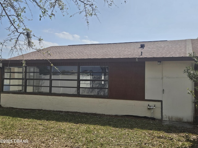 rear view of property with roof with shingles
