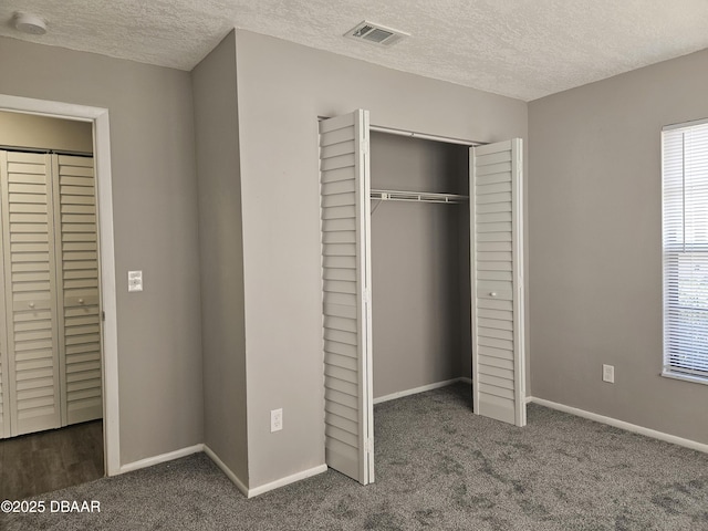 unfurnished bedroom with carpet, baseboards, a closet, and visible vents
