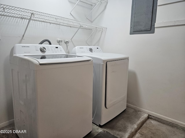 washroom featuring electric panel, washer and clothes dryer, laundry area, and baseboards