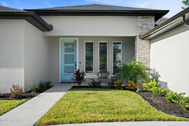 view of exterior entry with covered porch, a yard, and stucco siding