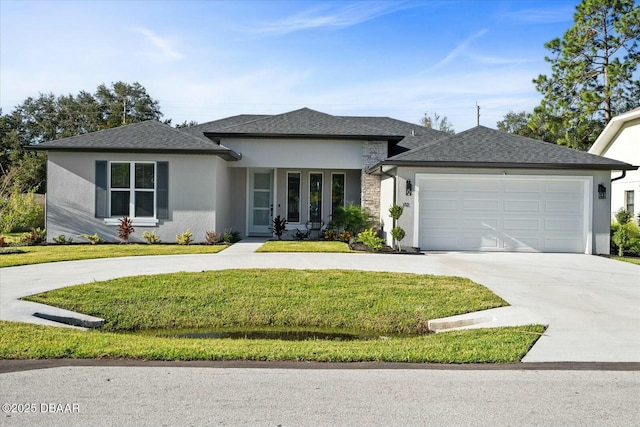 prairie-style home featuring an attached garage, a shingled roof, driveway, stucco siding, and a front yard