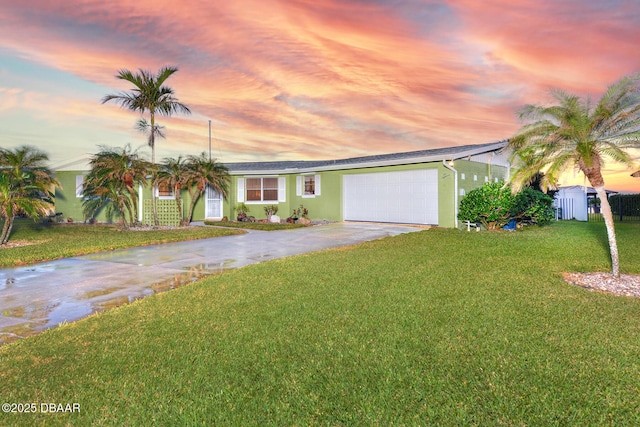 ranch-style home featuring a garage and a yard