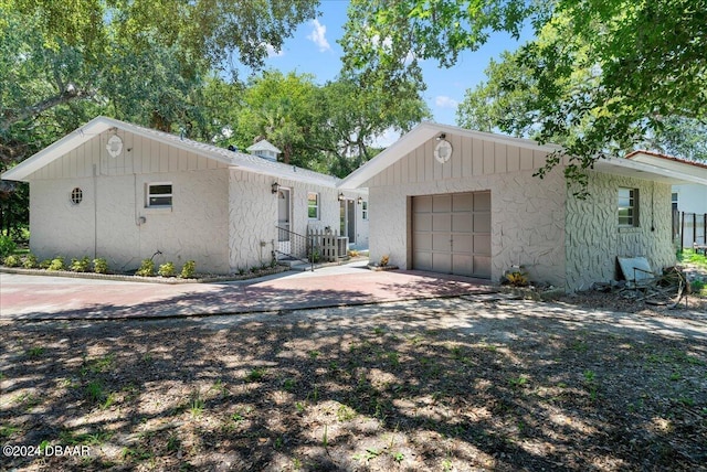 single story home featuring a garage, central AC, and an outbuilding