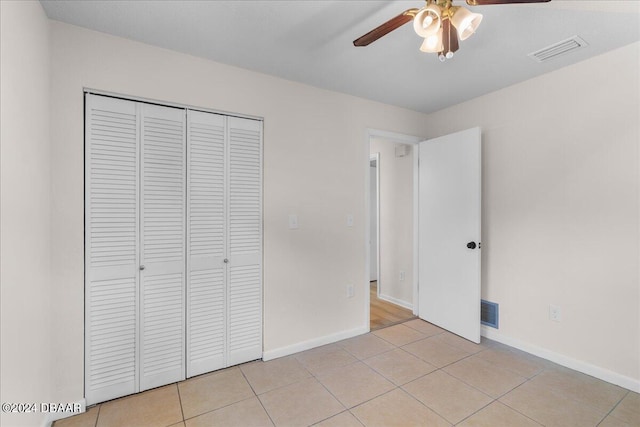 unfurnished bedroom with ceiling fan, a closet, and light tile patterned floors