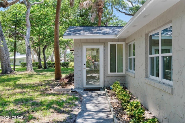 property entrance with a lawn