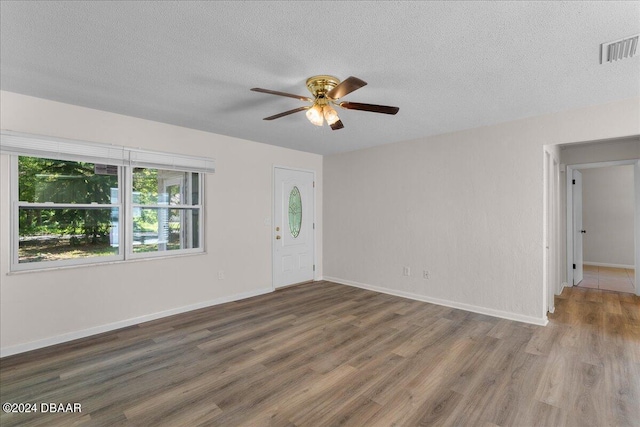 spare room with ceiling fan, a textured ceiling, and dark hardwood / wood-style floors