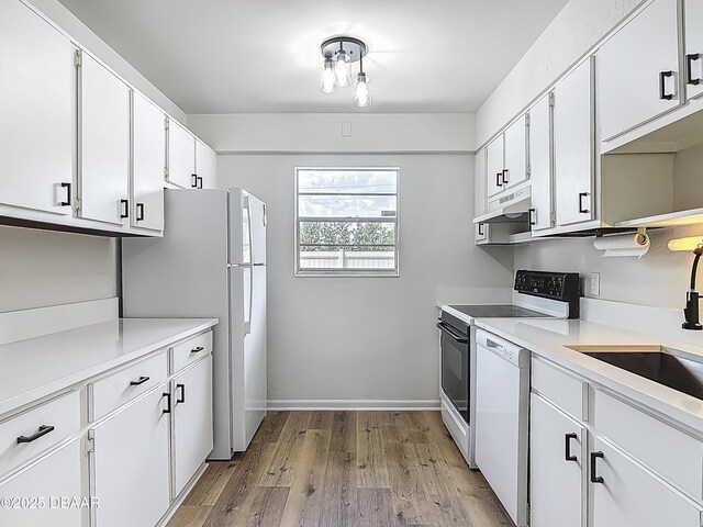 244 Oakleigh Dr, Deland, FL 32724 - kitchen with white appliances, light wood-style floors, a sink, under cabinet range hood, and white cabinets