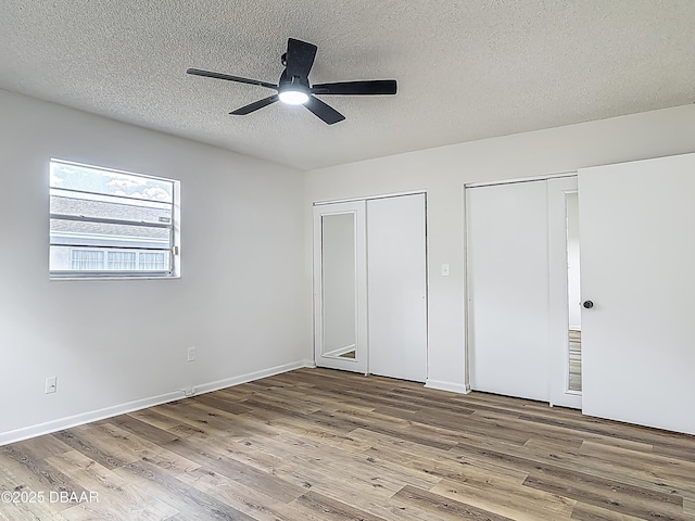 244 Oakleigh Dr, Deland, FL 32724 - unfurnished bedroom with multiple closets, wood finished floors, a textured ceiling, a ceiling fan, and baseboards