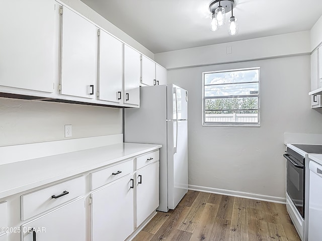 244 Oakleigh Dr, Deland, FL 32724 - kitchen with electric range, freestanding refrigerator, light wood-style flooring, white cabinetry, and light countertops
