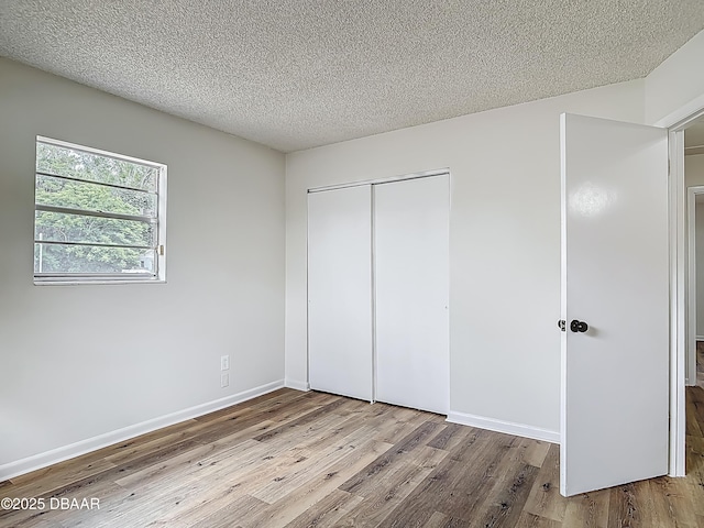 244 Oakleigh Dr, Deland, FL 32724 - unfurnished bedroom with wood finished floors, a closet, a textured ceiling, and baseboards