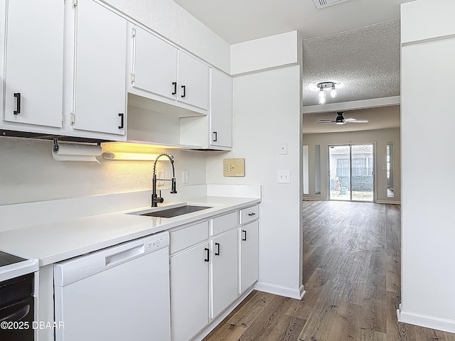 244 Oakleigh Dr, Deland, FL 32724 - kitchen featuring white dishwasher, a sink, wood finished floors, light countertops, and white cabinets