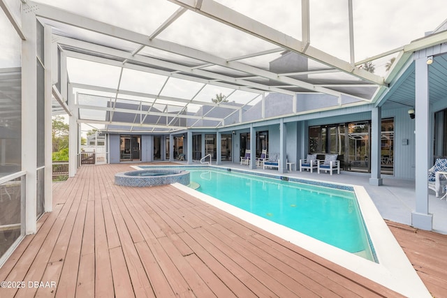 view of pool with glass enclosure, a patio, a pool with connected hot tub, and a wooden deck