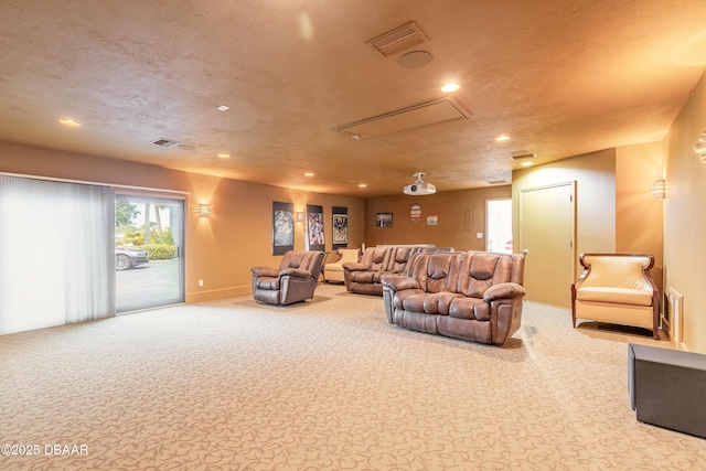 carpeted living area featuring recessed lighting, visible vents, a textured ceiling, and attic access