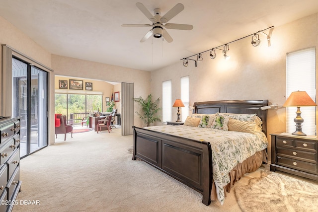 bedroom featuring light colored carpet, track lighting, and access to outside