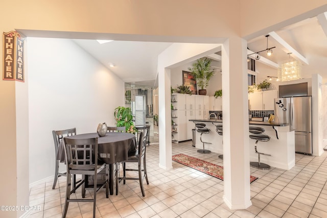 dining space featuring lofted ceiling and light tile patterned floors