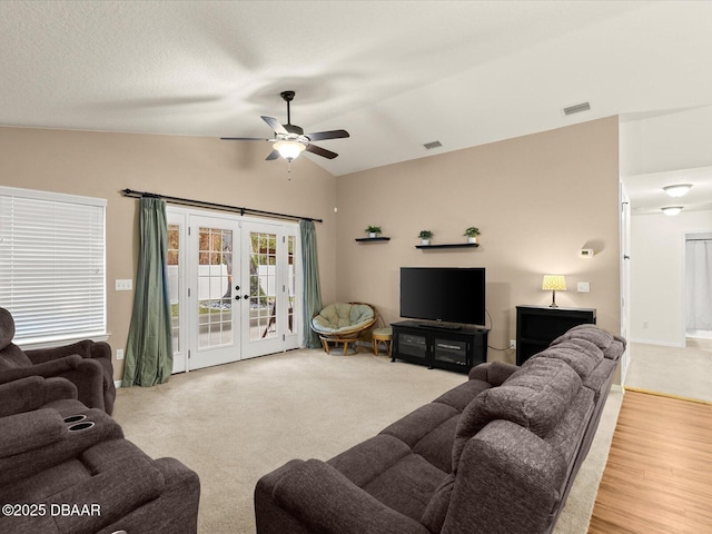 living room with french doors, lofted ceiling, ceiling fan, a textured ceiling, and light hardwood / wood-style flooring