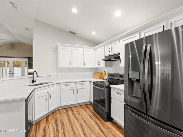 kitchen featuring lofted ceiling, stainless steel appliances, sink, and white cabinets