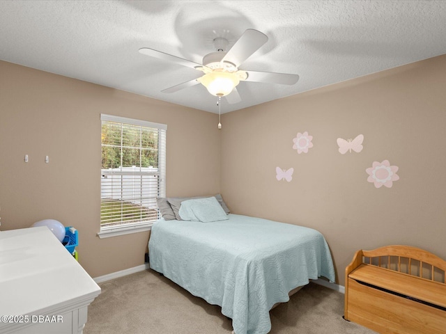 carpeted bedroom featuring ceiling fan and a textured ceiling