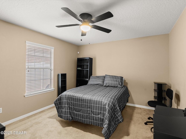 bedroom with ceiling fan, light carpet, and a textured ceiling